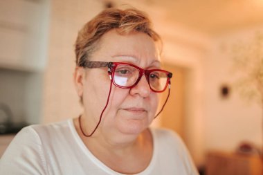 Captivating Portrait of a Real, Overweight Woman at Home This photo showcases the authentic beauty of an elderly, blonde female with glasses in her own home.
