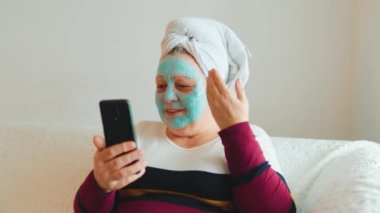 Kilolu Yaşlılar Selfie Oyunu 'ndan memnun oldum. Altın yıllarındaki gerçek bir kadın yüzünde maskeyle evde dinlenirken komik bir anı yakalıyor. Bu otantik ve yaş-pozitif