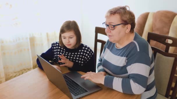 各种年龄的老妇人一起在家里学习 用她们的手提电脑进行研究和学习 这个孩子正在向同学们解释一个新的想法 同学们都很认真地听着 急于扩大他们的知识 — 图库视频影像