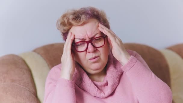 Oudere Vrouw Ervaren Een Intense Hoofdpijn Met Haar Handen Strak — Stockvideo