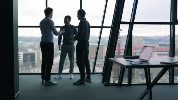 仕事の話をしている3人の若いサラリーマン ラップトップで生産的な会議をしている男性同僚のグループ — ストック動画