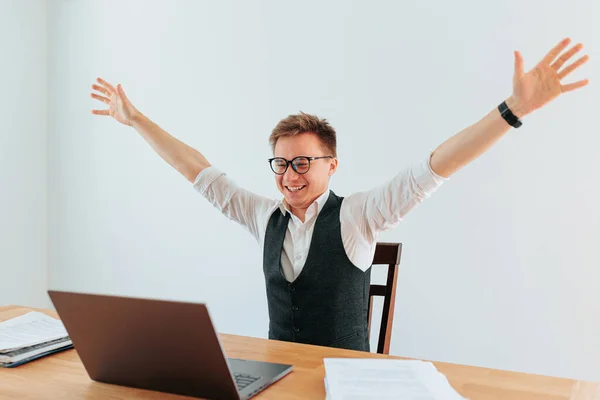 stock image A of an office workers as he finishes a challenging task on his computer. The sense of accomplishment and satisfaction is visible in his expression, showing how much he enjoys his job.