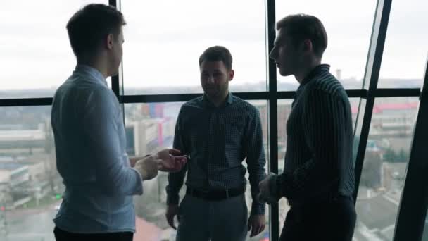 ビジネスマンと彼の2人の男性の同僚はアイデアを共同で話し合います 3人の男がブレインストーミングし オフィスでビジネス戦略を議論 — ストック動画