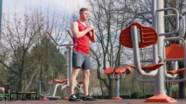 Dışarıda beden eğitimi yapan genç bir sporcu. Genç bir adam fiziksel antrenman ve spor aktivitelerine katılır. Açık havada spor hedeflerine ulaşmak için vücudunu limitlerine kadar zorlar..