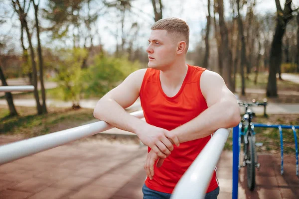 stock image Red T-Shirt and Sportswear on a Young Athlete A Portrait of Strength and Style Outdoors. Portrait of a Stylish Young Guy in Authentic Red Sportswear A Model of Youth and Confidence Outdoors