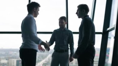 İş yerindeki iş adamları dizüstü bilgisayarları açık tartışıyorlar. Bir grup erkek iş arkadaşı iş planlarını tartışıyor.