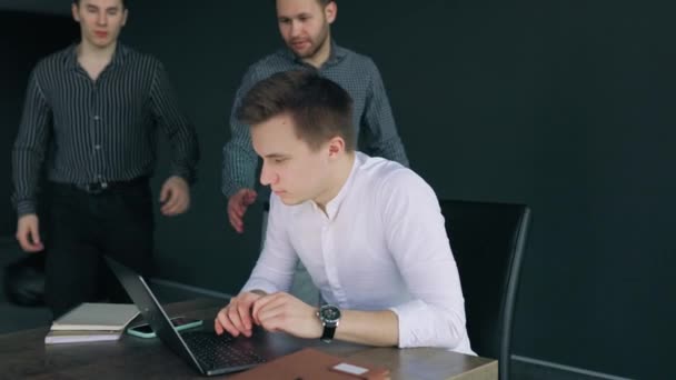 Trzech Młodych Mężczyzn Biurze Omawiających Sprawy Służbowe Patrząc Ekran Laptopa — Wideo stockowe