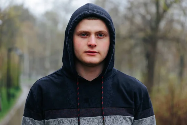 stock image Young Male with Captivating Eyes in Outdoor Portrait on Rainy Day. The candid portrait of a guys face in the rain conveys his calm and collected demeanor.