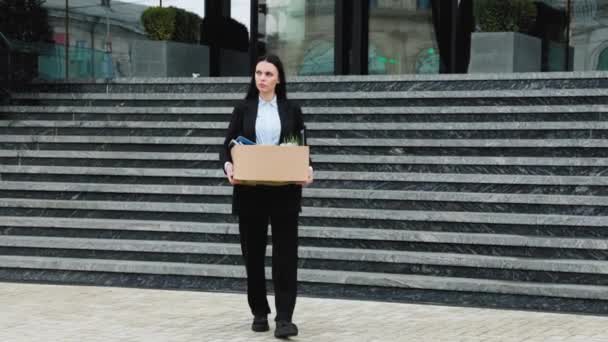 一个女人拿着一个纸盒的照片 上面写着解雇 因为失业而带着悲伤的表情走在外面 — 图库视频影像