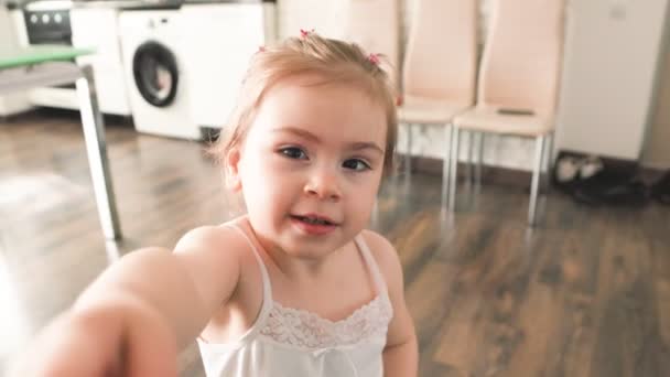 Mała Dziewczynka Siedzi Domu Patrząc Prosto Kamerę Mieszanką Emocji Twarzy — Wideo stockowe