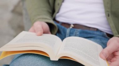 Bu yakın plan fotoğrafta, bir çift elin bir kitabı tuttuğunu ve dikkatle okuduğunu, edebiyat dünyasına daldığını görebilirsiniz. Bilgi Yakından Öğrenme Elle Yapılandırma