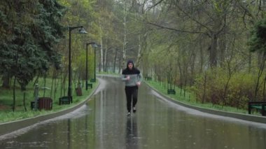 Man vs Rain an Outdoor Egzersiz Savaşı. Yağmurda antrenman yapan atletik bir adam. Kendini hava şartlarına adamış.