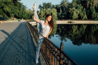 Açık havada Formda Genç Beden Eğitimi. Parkta egzersiz yapan genç bir kız. Gençlik Sağlıklı Yaşam Tarzı ve Beden Eğitimi