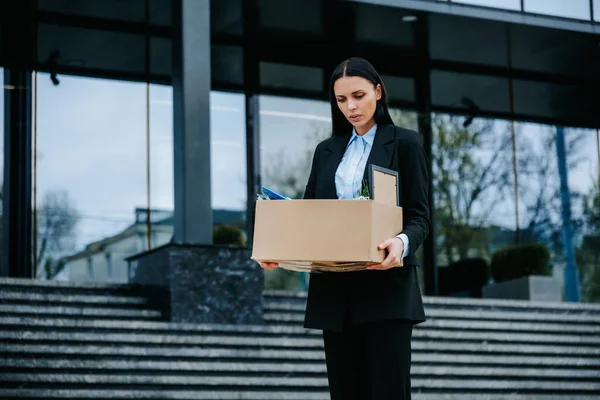 Stress and Worry in the Face of Work Loss. An upset person holds a cardboard box after experiencing workloss and job loss.