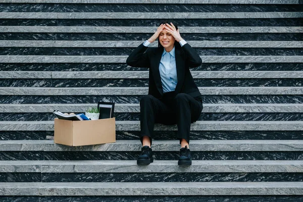 stock image woman on stairs, reflecting on her situation after dismissal and workloss, Fired and Feeling Lost A Woman Sitting on Stairs with Workless Sign