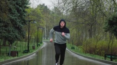 Yağmurlu bir günde A Elements A Men Outdoor Fitness Rejimi 'nde antrenman. Yağmurda antrenman yapan genç bir adam. Yoğun antrenmanında sağlıklı olmaya odaklanmış ve kendini adamış..