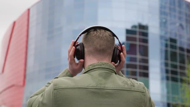 Young American Guy Earphones His Head Enjoying Music While Gazing — Stock Video