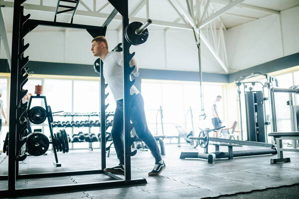 A motivated individual sweating it out in a training gym, utilizing barbells to engage in a variety of physical exercises, all aimed at improving overall fitness and strength.