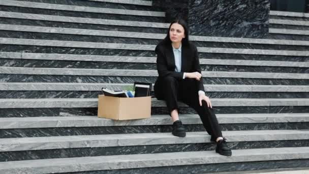絶望の表情をした女性は 解雇された仕事と収入の損失のニュースを受け取ったばかりで 外の階段に一人で座っています 外で不安を感じる中年女性 — ストック動画