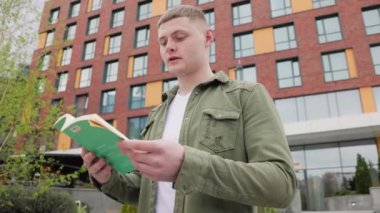 Parkta kitap okuyan bir adam, hikayeye kendini tamamen kaptırmış ve bunalmış. Doğada Okuduğu Kelimeler Bulmacası Olan Bir Adam Okuyor
