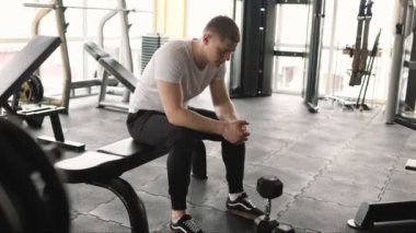 Gençleştirici anlar. Yorgun bir adam yoğun bir spor salonundan sonra teselli ve rahatlama bulur. Yorgun ve çok çalışan bir adam spor salonundaki zorlu egzersizden sonra rahatlar..