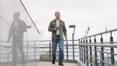 Genç bir İspanyol tek başına geziyor, açık havada eğlenirken akıllı telefonuna göz atıyor. Çevrimiçi alışveriş ve gezmek için şehir koşuşturmasına ara verdim.