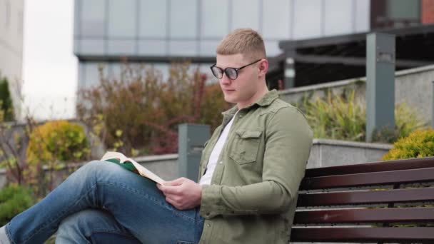 Hombre Bookworm Disfrutando Naturaleza Durante Lectura Hombre Joven Absorto Lectura — Vídeo de stock