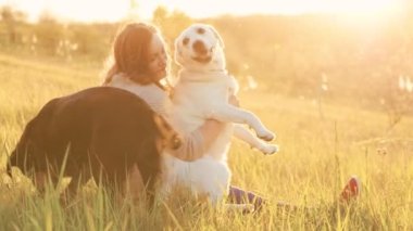 Günbatımı maceraları. Kadınlar sevgili köpekleriyle dışarıda eğleniyor. Kadınların gerçek kahkahaları dışarıdaki köpekleriyle oynarken havayı dolduruyor.