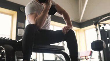 Bir erkek atlet, spor salonunda ağırlık kaldırma egzersizi yaparak gücünü ve gücünü gösteriyor. Sporcu, spor salonundaki fitness hedeflerine ulaşmak için yoğun bir antrenman yapıyor.