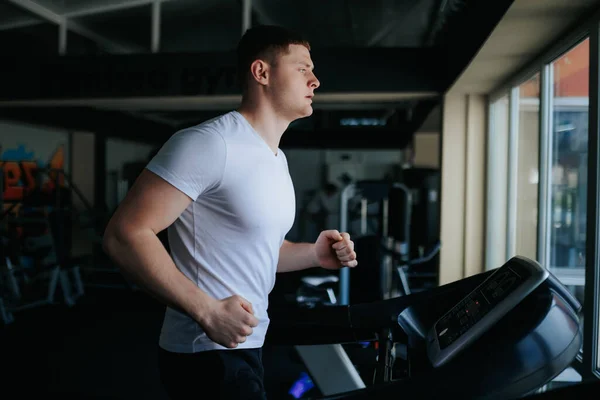 stock image A male sportsman sweating profusely while doing cardio and other physical exercises at the training gym. Fit and Focused The Power of Cardio and Gym Training for Men