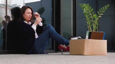Kariyer Hayal Kırıklığı 'nı yansıtan Depresyondaki Kadın Dışarıda Oturuyor. Umutsuzluğun derinliklerinde Eyüp Reddetmenin Yüzünde Otururken