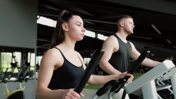 ヒスパニック系男性と白人女性のフィットネス 心臓のトレーニングルーチンに従事する男と女のフィット 健康のための精力的なヒスパニックとアメリカのペア運動 — ストック動画