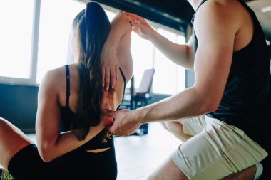 Profesyonel Fizyoterapi Erkek Kayropraktik Uzmanı Spor Salonundaki Kadına Uzman Yardım Ediyor. Kadın sağlığı için bütünsel yaklaşım spor salonundaki bir erkek terapistten profesyonel yardım alır.