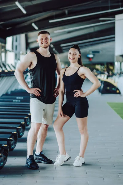 stock image Fitness enthusiasts Portrait of a man and woman in the gym, confident gazes at the camera. Fitness Partners Dynamic Gym Portrait of a Young Man and Woman