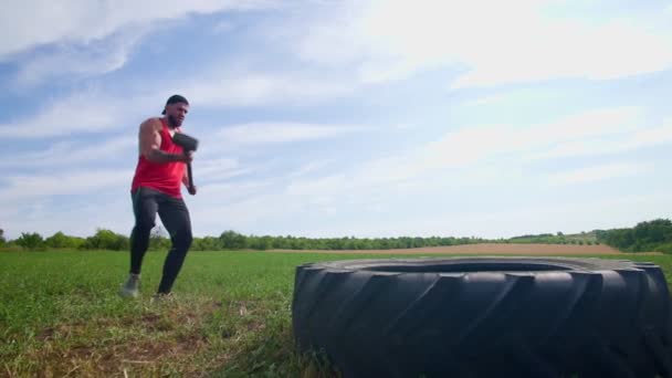 慢速运动员肌肉男注意力量 用大锤打橡胶轮胎室外 肌肉动力屋男子展示力量通过打铁丝在交叉配合训练室外 — 图库视频影像
