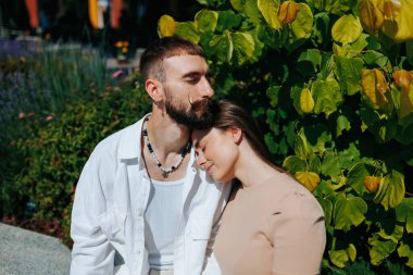 Açık havada birlikte gülen genç bir çiftin portresi..