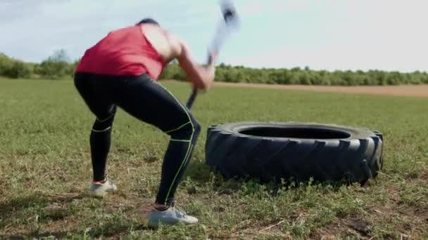 户外运动健美男子进行力量训练 在课上摔碎橡胶轮胎 户外训练中的交叉配合挑战肌肉男子用大锤击破铁丝 — 图库视频影像