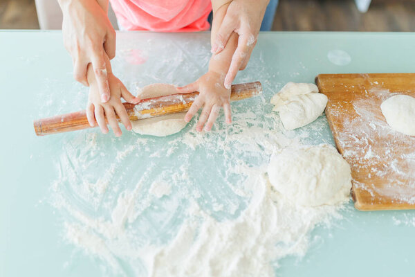 close up hands glimpse into the domestic happiness of a mother and daughter in the kitchen, preparing dough and sharing the sweetness of family. Treasured Moments Mother and Daughters Doughy