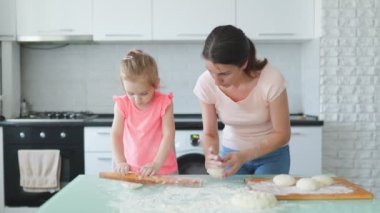 Aile mutluluğunu kucaklayan bir anne ve kızı, mutfakta ailecek geçirdikleri zamanı kutlayarak hamurlarını yan yana yoğururlar. Anne ve Kızıyla Mutfakta Aile Mutluluğu Anıları Oluşturmak