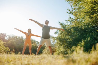 Sabah jimnastiği. İki kişi fiziksel egzersiz yapıyor. Aktif ve Güçlü Erkek ve Kadın Sporcular Açık Hava Sporları, Atletizm Ruhu