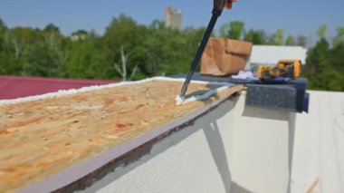 Bu ilgi çekici portrede, erkek işçilerin ellerinin dikkatlice köpüğü yerleştirdiğini görüyoruz. Bu inşaat işçisi, gerçek bir profesyonel.,