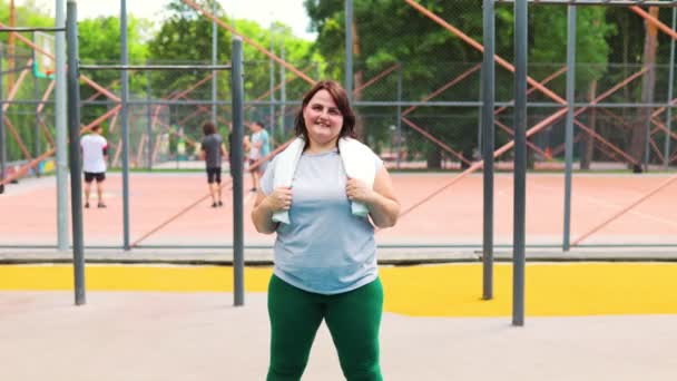一个自信地运动着的美国女人 展示着她的健康和活泼的身体 她灿烂的笑容反映了她在运动之后的快乐和满足 — 图库视频影像