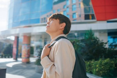 Üniversite bahçesinin kalbinde, Asya 'lı çalışkan bir öğrencinin portresi kendini akademi dünyasına daldırıyor, bilgi arayışı ile doğanın zevklerini harmanlıyor..