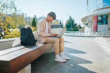 Açık hava kampüsünün dinginliğinin ortasında, kendini adamış bir öğrenci olan genç bir Asyalı Koreli, çalışmalarıyla meşgul oluyor. Dizüstü bilgisayarı, bilgi dünyasına açılan kapıdır. 