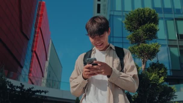 Young Korean Guy Estudante Experiências Satisfação Seu Diálogo Telefônico Móvel — Vídeo de Stock