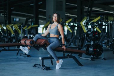 Spor salonunda, İspanyol kökenli neşeli ve güzel bir kadın, sağlıklı bir yaşam tarzının özünü somutlaştıran çarpıcı bir portre için poz verir..