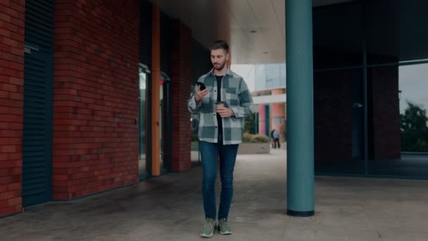 Vista Frontal Joven Caminando Hablando Teléfono Inteligente Afuera Ciudad Involucró — Vídeos de Stock