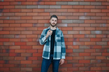 Şehrin tam ortasında, güzel bir genç adam bu açık hava görüntüsünde güzel bir şekilde resmediliyor. Güzel genç adam şehir dışındaki portrede kameraya bakıyor.