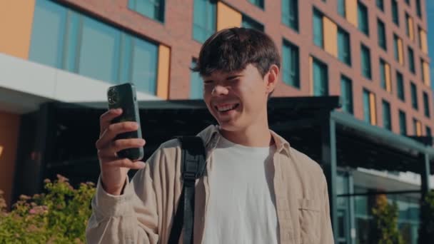 동료와 온라인 채팅에 종사하는 만족스러운 청소년 아시아인 스마트 — 비디오