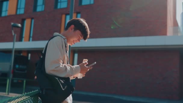 Разговоры Открытом Воздухе Улыбающийся Азиатский Студент Кореец Смеющийся Разговаривая Смартфону — стоковое видео
